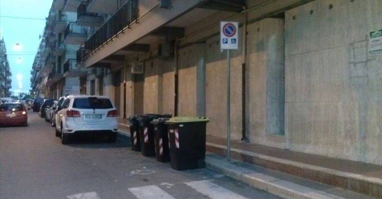 contenitori dei rifiuti collocati sul posteggio per disabili