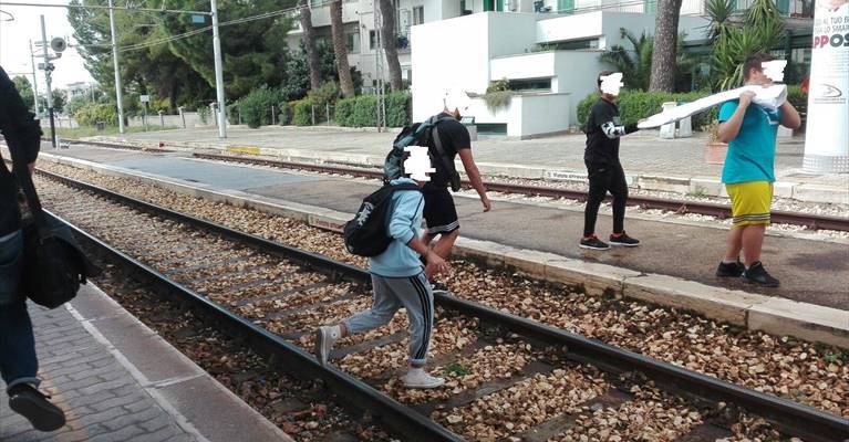 pendolari che attraversano i binari